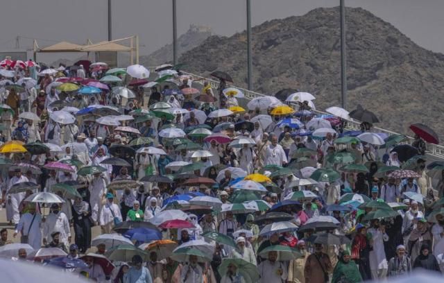 Muslim pilgrims use umbrellas to shield themselves from the sun as they arrive to cast stones at pillars in the symbolic stoning of the devil the last rite of the annual hajj in Mina near the holy city of Mecca Saudi Arabia on June 18 2024 AP-Yonhap