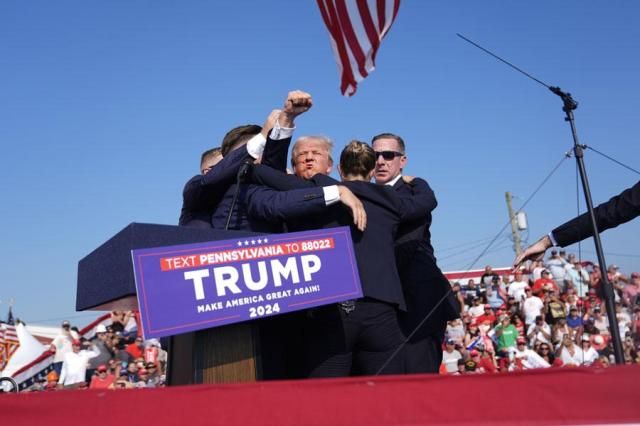 Republican presidential candidate former President Donald Trump gestures as he is surrounded by US Secret Service agents as he leaves the stage at a campaign rally in Butler Pennsylvania on July 13 2024 in Butler Pa on July 13 2024 AP-Yonhap