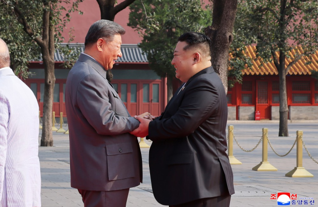 Chinese President Xi Jinping left shakes hands with North Korean leader Kim Jong-un right before the start of China’s Victory Day military parade in Beijing on September 3 2025 KCNAYONHAP