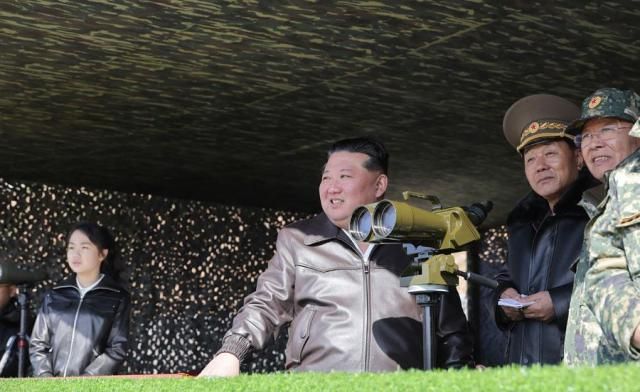 North Korean leader Kim Jong-un center along with his daughter Ju-ae far left oversees a drill at a military base in Pyongyang on March 18 2026 in this photo released by the state-run North Korean Central News Agency the following day