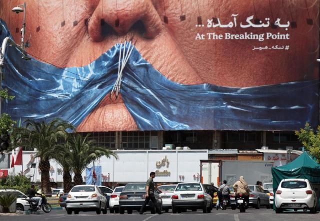 Iranians walk in front of a large anti-US billboard featuring US President Donald Trump in Tehran Iran on May 21 2026 EPA-Yonhap