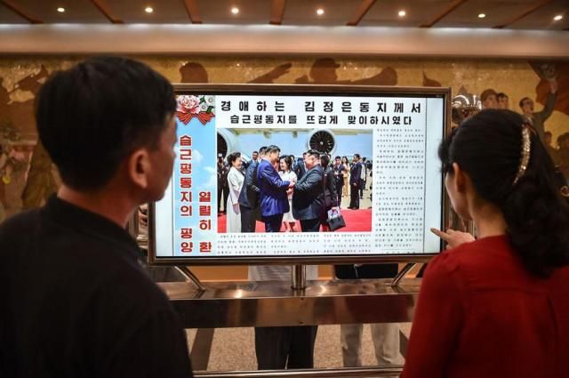 North Koreans look at a screen showing the state-run Rodong Sinmun newspaper carrying coverage of Chinese President Xi Jinpings visit to North Korea at a railway station in Pyongyang on June 9 2026 AFP-Yonhap