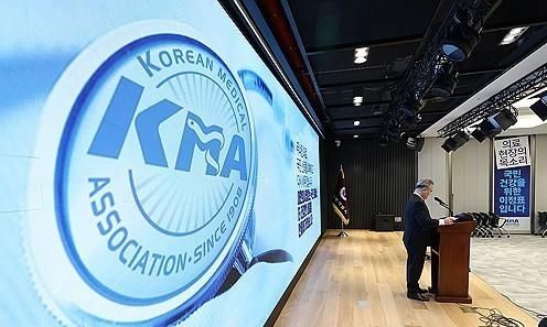 A speaker delivers remarks at a Korean Medical Association briefing as the association’s logo is displayed on a large screen Courtesy of Yonhap News Agency
