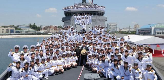 North Korean leader Kim Jong-un center poses for a group photo with sailors at a commissioning ceremony for a new destroyer at a port in Nampo on June 23 2026 in this photo released by the state-run North Korean Central News Agency the following day