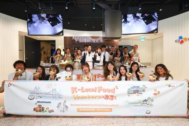 Overseas influencers taking part in the K-Local Food Hunters 33 campaign show off bowls of bibimbap during a Korean cooking class at CJ The Kitchen in Seoul on Monday Courtesy of Korea Tourism Organization 