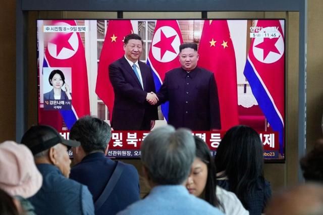 People watch a TV screen showing a file image of North Korean leader Kim Jong-un right and Chinese President Xi Jinping at a railway station in Seoul on June 5 2026 AP-Yonhap