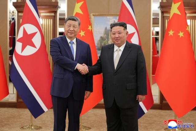 Chinese President Xi Jinping left shakes hands with North Korean leader Kim Jong-un during a summit in Pyongyang on June 8 YONHAPKCNA