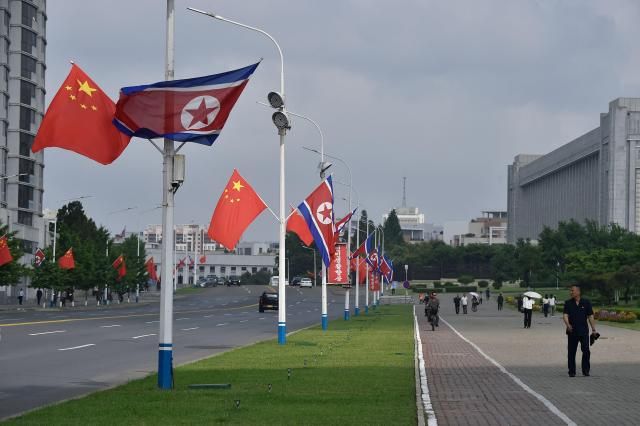 The national flags of North Korea and China are displayed on a street in Pyongyang on June 8 2026 Chinese President Xi Jinping arrived in Pyongyang on June 8 state news agency Xinhua reported for his first official visit to North Korea since 2019 AFP-Yonhap 