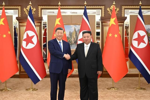 In this photo released by Xinhua News Agency Chinese President Xi Jinping left and North Korean leader Kim Jong-un shake hands for a photo at Kumsusan State Guesthouse in Pyongyang Monday June 8 2026 AP-Yonhap 