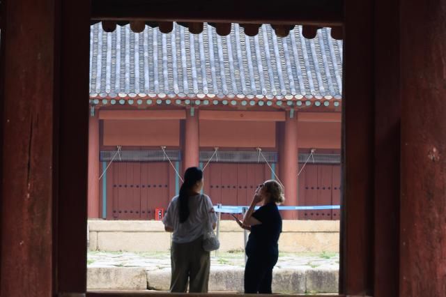 Foreign visitors look up at Jongmyo Shrines main hall in Seoul July 16 2026 as the UNESCO World Heritage site draws record numbers of overseas tourists AJP Han Jun-gu