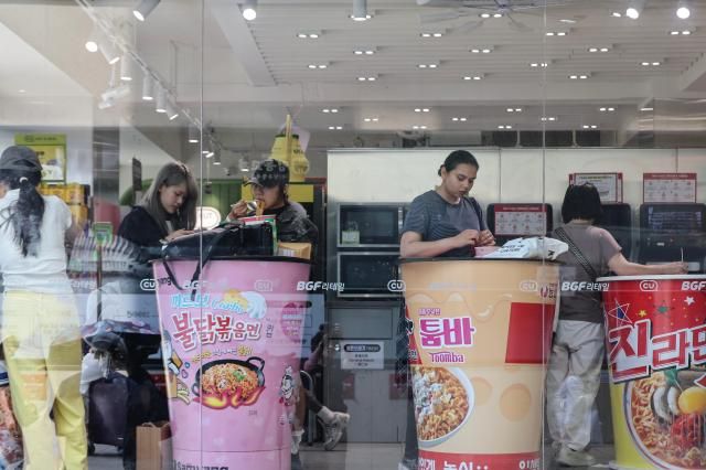 Tourists enjoying cup noodles in a convenient store in Myeongdong July 2026 AJP Yoo Na-hyun
