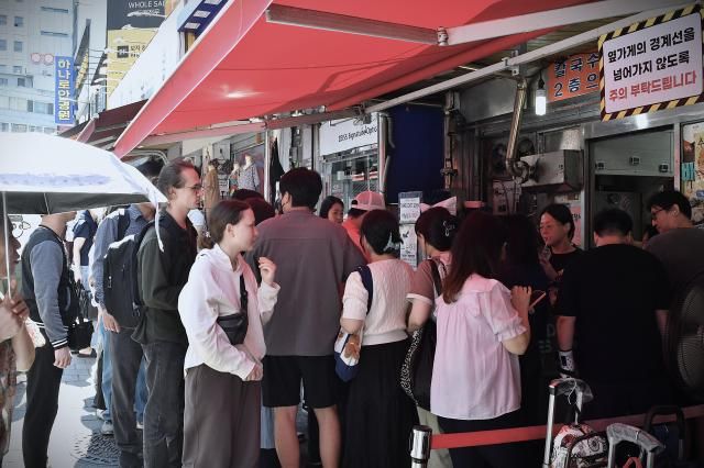 Visitors including foreign tourists line up outside a popular restaurant at Namdaemun Market in central Seoul Sept 22 2026 AJP Joonha Yoo
