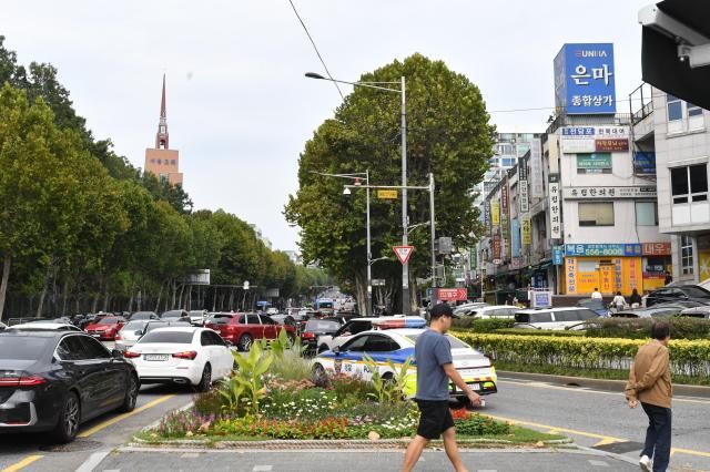 The busy road outside Eunma Sangga, lined with plane trees, local shops, and the iconic blue Eunma sign in the distance on Sept 25. AJP Joonha Yoo