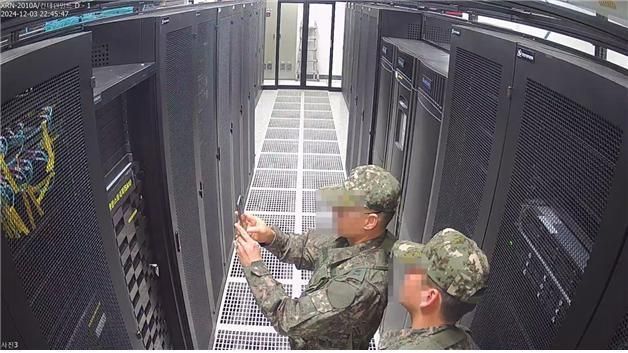 写真＝聯合ニュース（CCTVに記録された戒厳軍の選管システムサーバー撮影している）