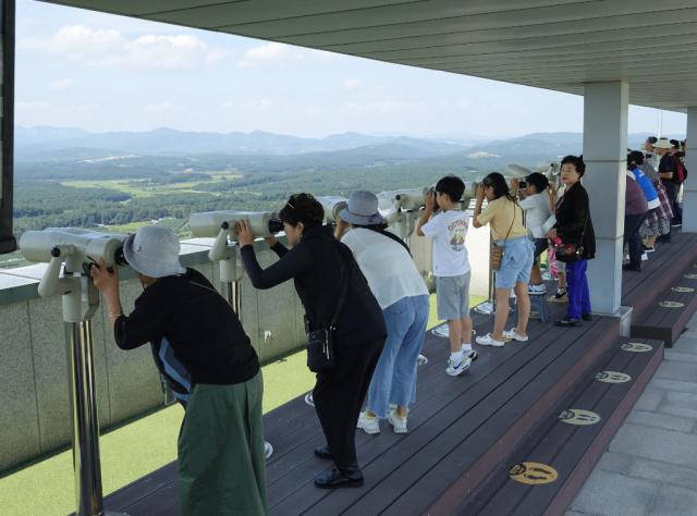 昨年、DMZ平和列車の利用客が都羅山展望台から設置された望遠鏡で北側を見回っている 写真京畿道北部庁