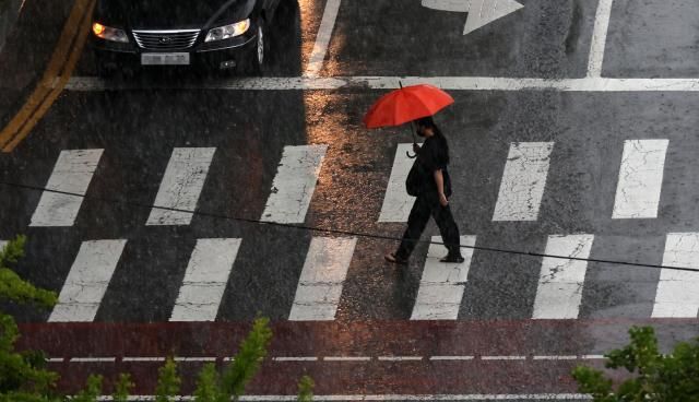 雨が降る16日、ソウル江南駅の通りで傘を差した市民たちが退勤を催促している 気象庁は同日、中部地方と湖南を中心に大雨を予報した 写真連合ニュース