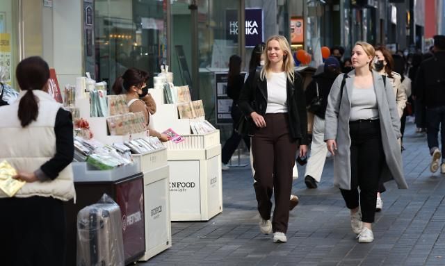 Khách du lịch nước ngoài đang đi dạo trên đường phố Myeong-dong, Jung-gu, Seoul vào chiều ngày 19/10/2022. 