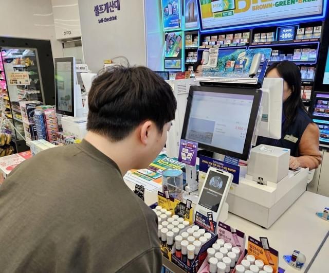 Một khách hàng thực hiện thanh toán bằng Toss Face Pay tại cửa hàng tiện lợi CU ẢnhCU