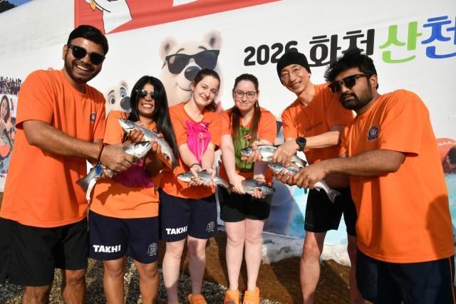 Du khách nước ngoài chụp ảnh lưu niệm sau khi câu được cá hồi trong Lễ hội Băng Hwacheon Sancheoneo năm 2026 ẢnhHuyện Hwacheon