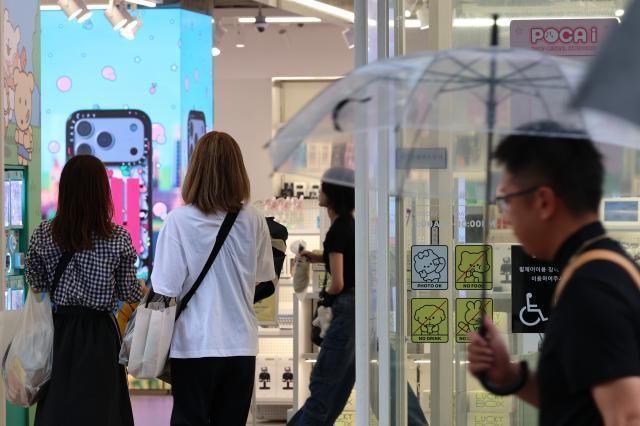 Ngày 207 du khách nước ngoài tham quan các cửa hàng trên phố Myeongdong Seoul Ảnh Yonhap News