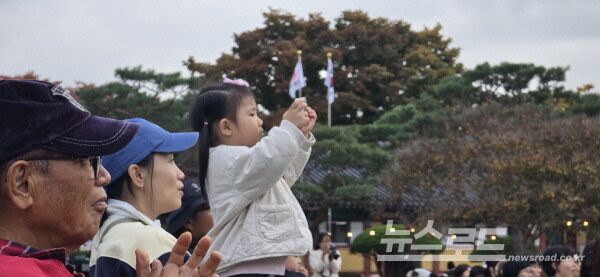 완월정 특설무대에서 펼쳐지고 있는 JI예술단의 줄타기 공연 촬영에 몰두하고 있는 어린이 관람객. 핸드폰 카메라 촬영 모습이 진지하면서도 앙증맞기만 하다. [사진=서진수기자]