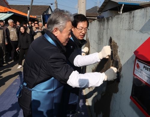 강호동&nbsp;농협중앙회장(왼쪽)이 22일 이만희 국회의원(오른쪽)과 함께 담장 도색을 하고 있다./연합뉴스