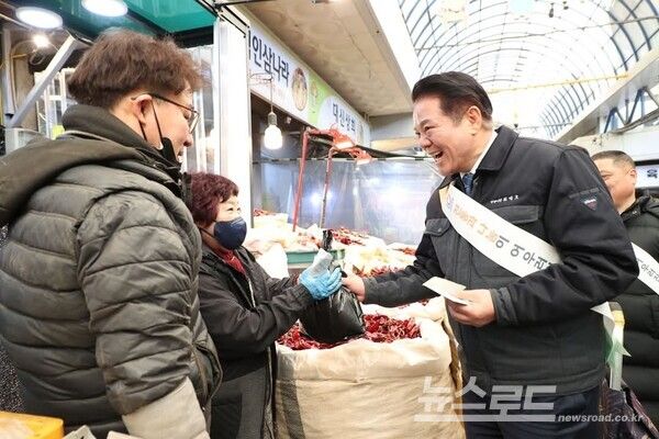 최대호 시장이 전통시장을 방문해 안양페이로 시장 상인의 물건을 구매하고 격려하고 있다. [사진=최대호 시장 페이스북]
