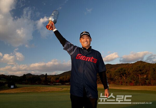 김재호가 아버지의 유니폼을 입고 우승 트로피를 번쩍들어 올리며 기뻐하고 있다./사진=KPGA