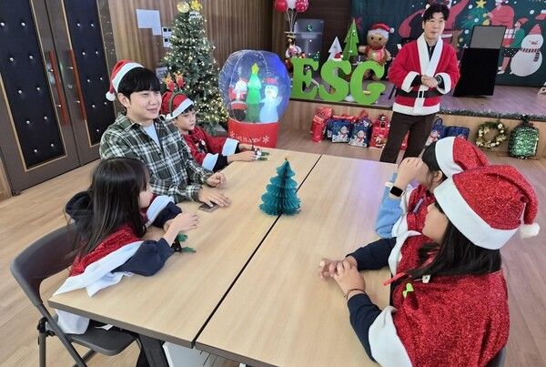 CJ올리브네트웍스 임직원이 지난 18일 효창종합사회복지관에서 열린 '크리스마스 파티'에 참석해 아이들과 함께 이야기를 나누고 있다.