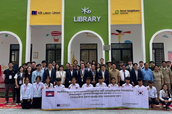 지난 21일 캄보디아 프놈펜에 위치한 댐낙앰필 중학교에서 열린 ‘KB라이브러리’ 개관식에 정훈영 KB국민은행지부 수석부위원장(두번째 줄 왼쪽에서 7번째), 옴쌈이온 KB 프라삭 은행장(두번째 줄 왼쪽에서 6번째), 장동원 굿네이버스 캄보디아 대표(두번째 줄 왼쪽에서 9번째)가 기념촬영을 하고 있다./사진제공=KB국민은행