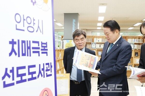 최대호 시장이 도서관 책자를 살피고 있다./사진=안양시