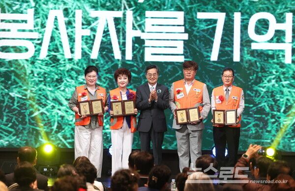 화성시 SINTEX에서 열린 2025년 경기도 자원봉사대회에서 김동연 경기도지사가 우수 자원봉사자 인증패 수여를 하고 기념촬영을 하고 있다./사진=경기도