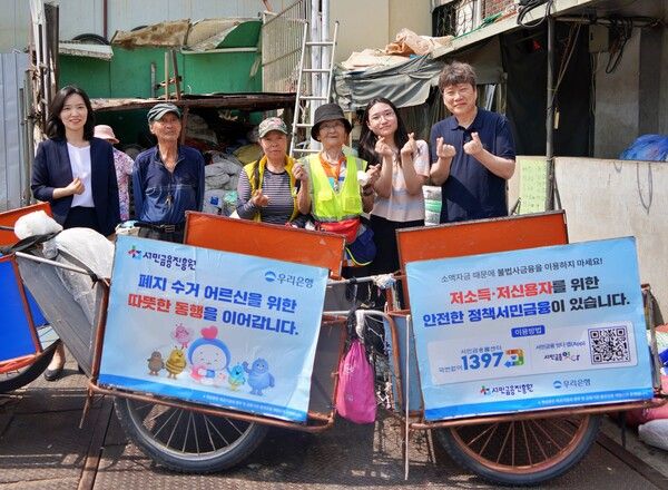 지난&nbsp;19일 우리은행,&nbsp;서민금융진흥원,&nbsp;협동조합 끌림이 함께 폐지수거 어르신들에게 경량 리어카와 안전용품을 제공했다.&nbsp;우리은행 하현신 상생금융부장(좌측)과 서민금융진흥원 신승주 홍보협력실장(우측)이 전달식 이후 어르신들과 함께 기념사진을 촬영하고 있다./사진제공=우리은행