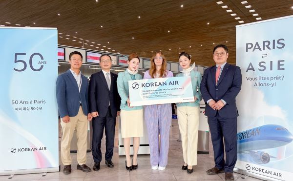 [사진=대한항공]지난 2일(현지시간) 오후 프랑스 파리 샤를 드 골 국제공항에서 KE902편 승객을 대상으로 여객 노선 취항 50주년 행사를 진행했다. 해당편에 50번째로 탑승 수속한 승객 제룰 시릴(왼쪽에서 네 번째)이 인천행 항공권 등 선물을 전달받고 대한항공 관계자들과 기념 사진을 촬영하고 있다.