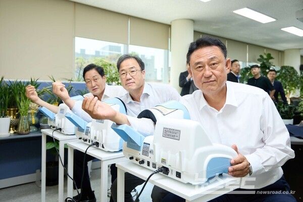 이충우 시장(오른쪽)이 SK하이닉스 정상록 부사장(가운데), 김선교 국회의원(왼쪽)과 자동 혈압계에서 혈압을 측정하고 있다./사진=여주시