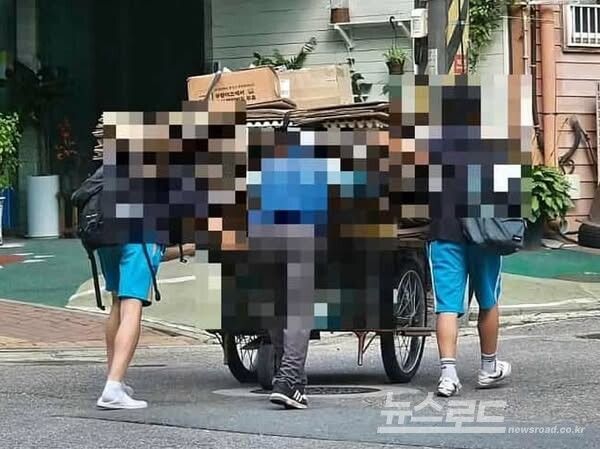 홀로 수레를 이끌고 가는 어르신의 수레를 성호중 학생들이 양쪽에서 끌고 가는 모습을 담은 모습이 SNS를 통해 알려졌다./사진=이민근 시장 페이스북