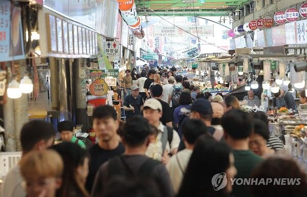 정부가 민생회복 소비쿠폰 1차 지급계획을 발표한 6일 서울의 한 전통시장을 찾은 시민들이 점포를 둘러보고 있다./연합뉴스