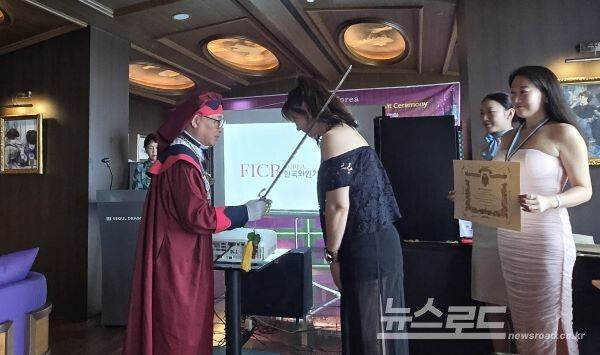 김베로니카씨가 김동준 한국와인기사단 총사령관으로부터 신임 기사 작위를 받고 있다. 오른쪽은 함께 작위를 받은 박보연씨. [사진=서진수기자]