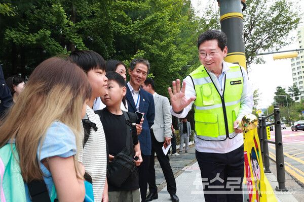 이상일 시장이 12일 수지구 현암초등학교에서 교통지도 봉사에 참여하며 학생과 인사를 나누고 있다./사진=용인시