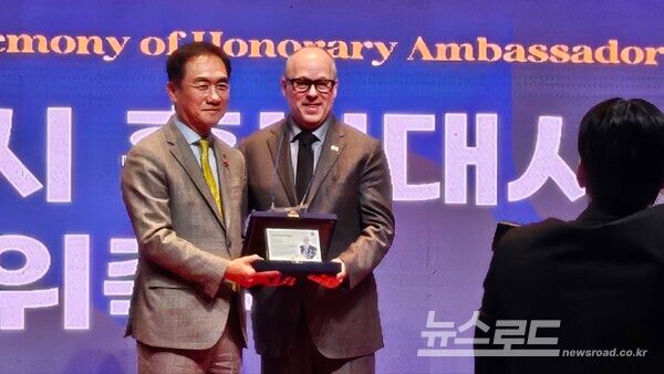 정장선 시장이 데이빗 오버튼 애니라이트 스쿨 이사장(오른쪽)에게 홍보대사 위촉을 하고 기념촬영을 하고 있다./사진=뉴스로드 김영식 기자&nbsp;