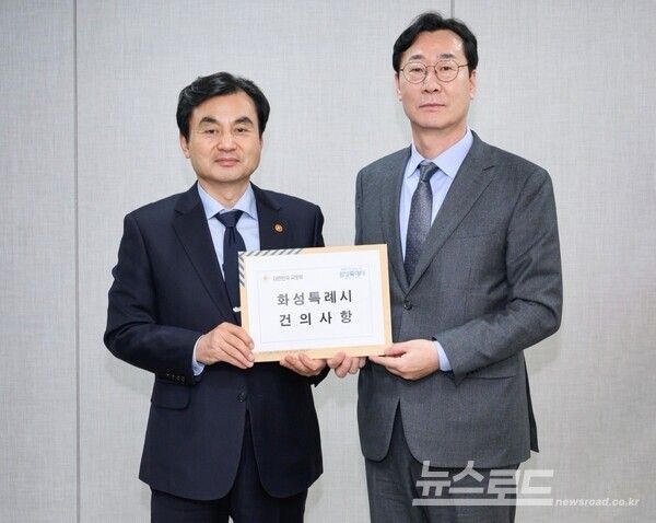 정명근 시장(우)이 안규백 국방부장관(좌)에게 건의문을 전달하며 기념촬영을 하고 있다./사진=화성시