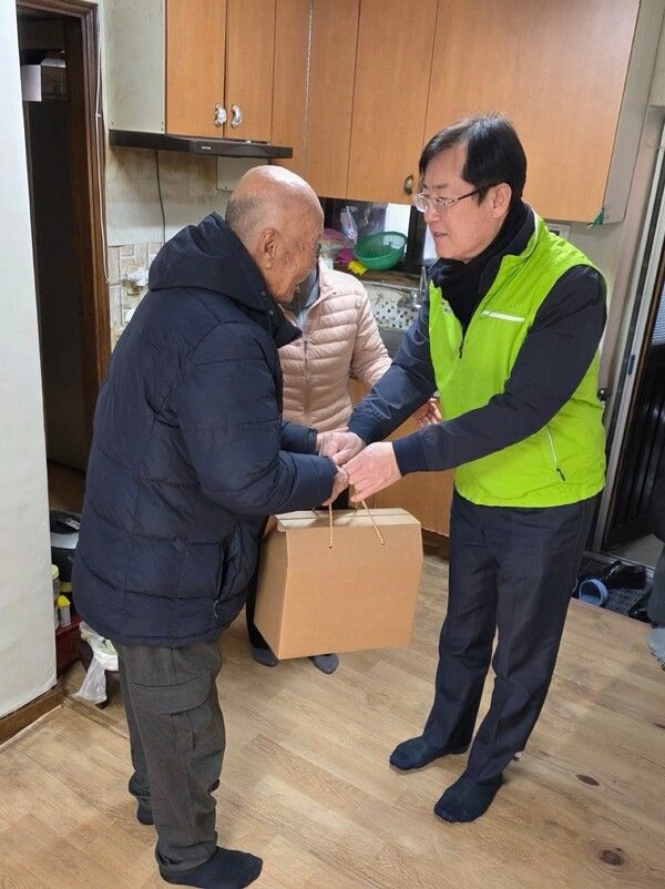 안병우 축산경제대표이사(오른쪽)가 2일 흑석종합사회복지관에서 독거노인에게 우리 축산물 꾸러미를 전달하고 있다.