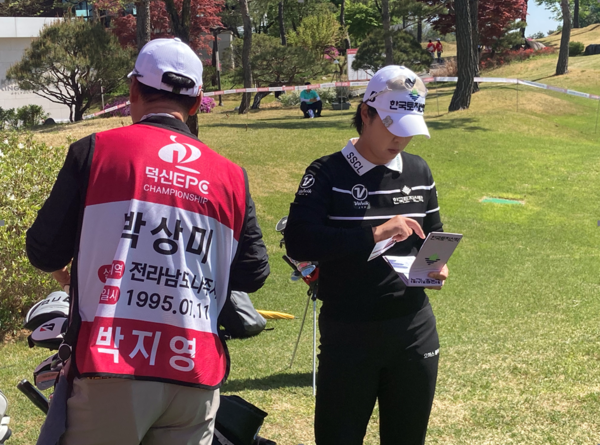 24일 충북 충주 킹스데일GC에서 열린 ‘제2회 덕신EPC 챔피언십’ 1라운드에서 박지영 프로가 실종아동 정보가 담긴 캐디복을 입은 캐디와 함께 경기를 준비하고 있다. (사진제공 대회조직위)