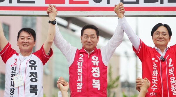 유정복 후보(가운데)가 강화풍물시장 유세 현장에서 안철수 의원, 박용철 강화군수 후보와 손을 맞잡고 지지자들에게 인사하고 있다. [사진=유정복 후보 캠프 제공]