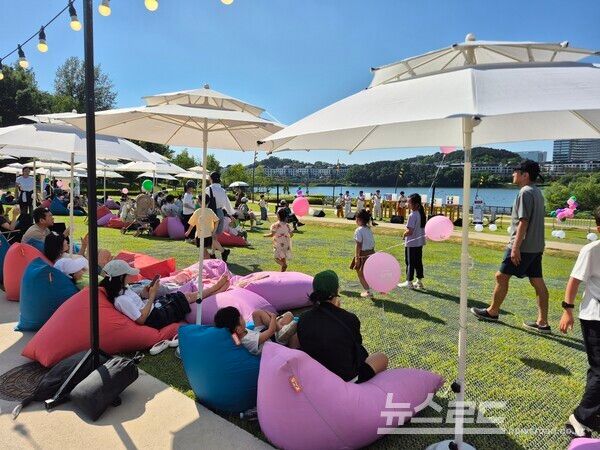 동탄호수공원 운답원을 찾은 시민들이 잔디밭에 마련된 빈백과 파라솔 아래에서 휴식을 취하며 평화통일문화행사의 여유로운 분위기를 만끽하고 있다./사진=화성시