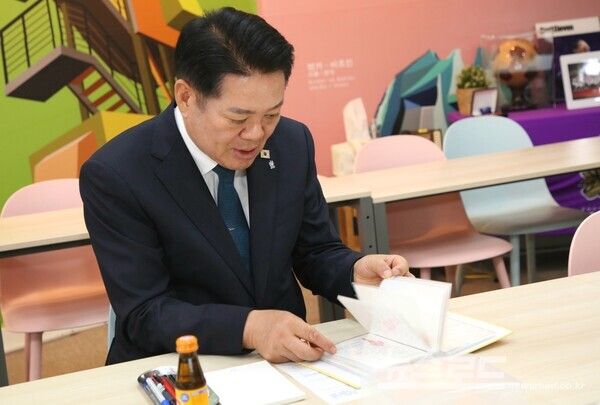 최대호 안양시장이 민백초등학교 어린이들이 직접 쓴 교통 감사 엽서를 읽어 보고 있다./사진=안양시