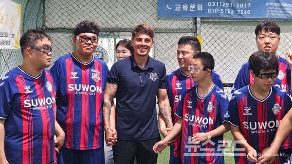 돌고래 FC 선수들이 축구 클리닉을 마치고 수원FC 윌리안 선수곁에 모여 기념촬영을 하고 있다./사진=뉴스로드 김영식 기자