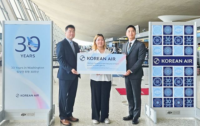 7월 25일 KE094편 탑승객 중 30번째로 수속한 승객 이윤주씨와 이병훈 대한항공 미동부지점장(왼쪽), 석인학 워싱턴공항지점장(오른쪽)이 함께 기념 촬영을 하는 모습