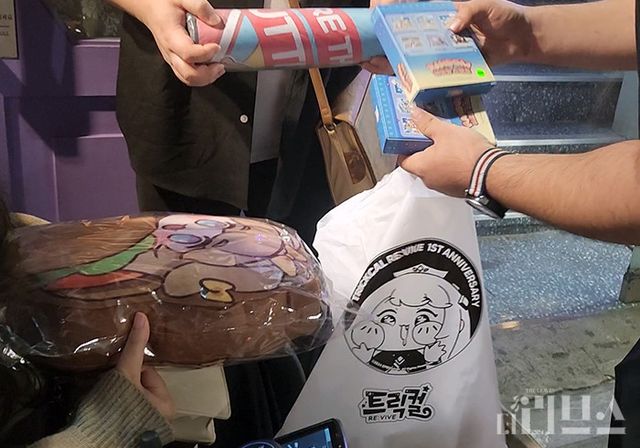 에피드게임즈 관계자가 A씨에게 게임 캐릭터 '버터' 관련 상품을 제공하고 있다. [사진=황민우 기자]