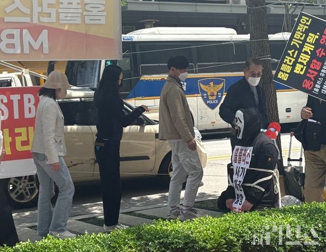 규탄집회에 참석한 홈플러스 전단채 피해자들이 MBK 김병주 회장을 상징하는 인물을 포승줄로 묶고 처벌 퍼포먼스를 하고 있다. [사진=양하영 기자]